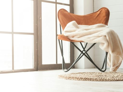 brown wooden chair near white textile on brown wooden floor