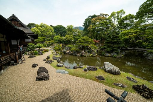 wooden houses near pond with rocks at daytime