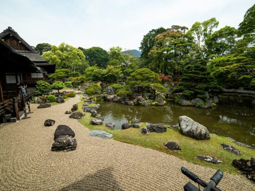 wooden houses near pond with rocks at daytime