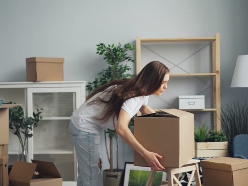 a woman moving boxes in a living room