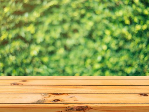 A wooden table surface with a vibrant green garden background in soft focus.