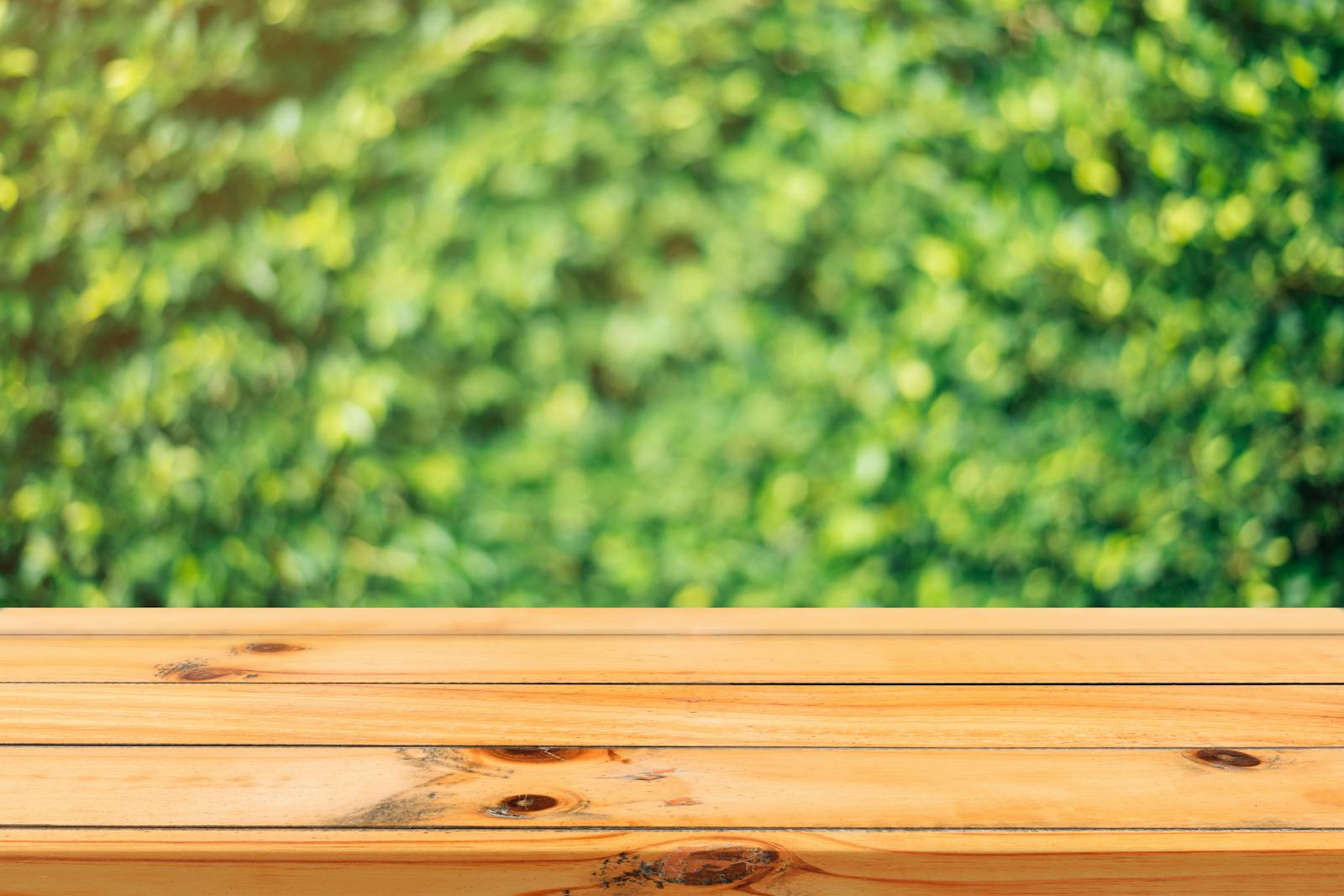 A wooden table surface with a vibrant green garden background in soft focus.