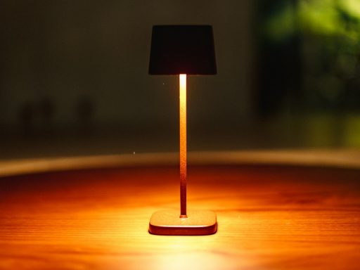 A small lamp illuminates a wooden table.