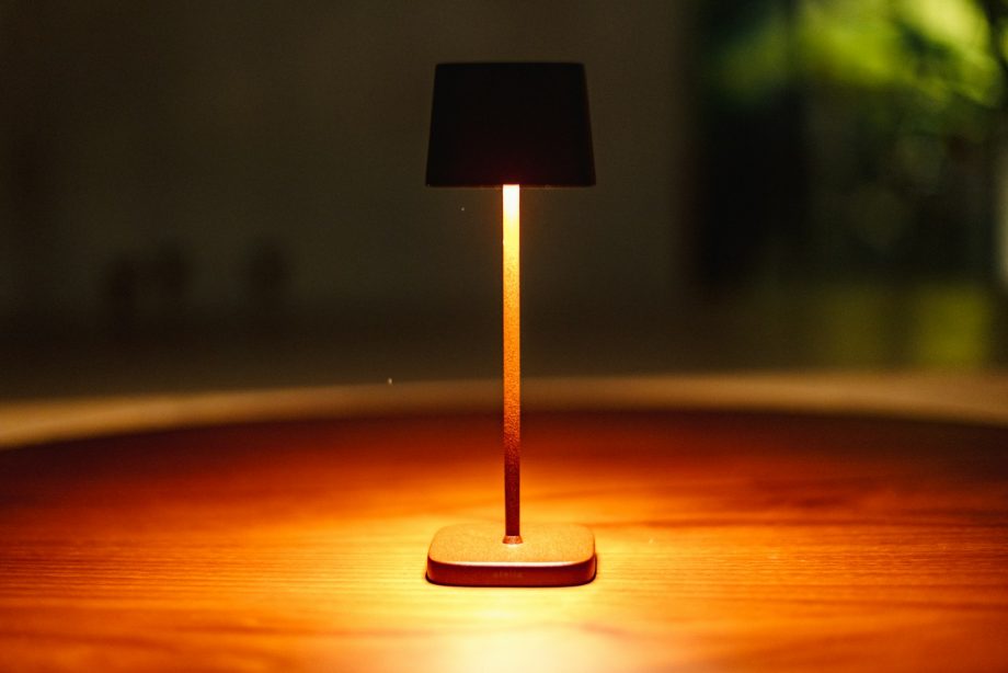 A small lamp illuminates a wooden table.