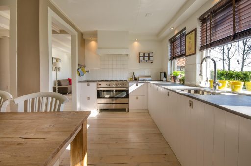 Lichte Scandinavische woonkamer met houten meubels, linnen gordijnen en een gezellige vloerlamp