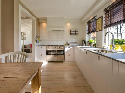 Lichte Scandinavische woonkamer met houten meubels, linnen gordijnen en een gezellige vloerlamp