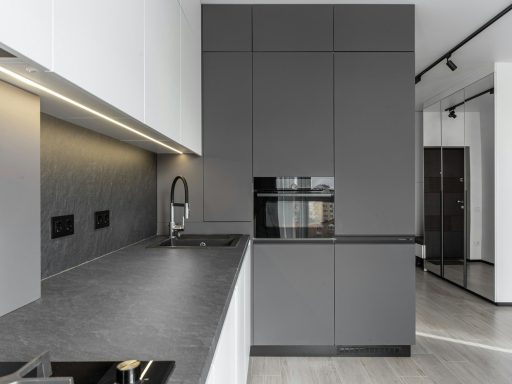 Modern kitchen features sleek gray cabinetry and design