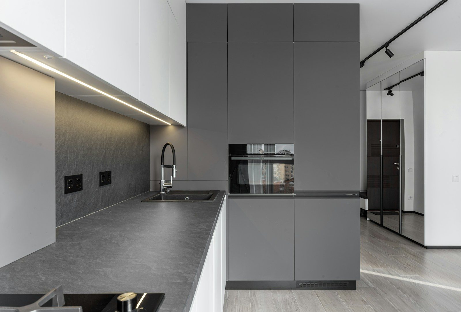 Modern kitchen features sleek gray cabinetry and design