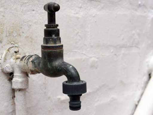 Druppelirrigatiesysteem met slangen en druppelaars in een zomertuin, klaar om te worden demonteerd voor de winter