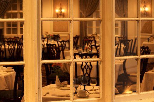 Sfeervol restaurantinterieur met warme verlichting en eiken tafels als inspiratie voor de eetkamer thuis