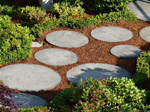 Tuinpad van gebakken klinkers en natuursteen in een verzorgde tuin