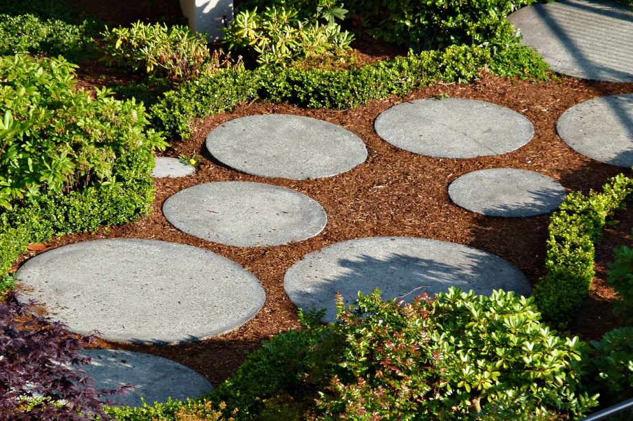 Tuinpad van gebakken klinkers en natuursteen in een verzorgde tuin