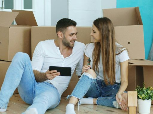 Couple looking at tablet surrounded by moving boxes