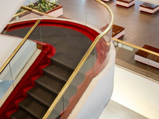 Modern staircase with glass railings and red accents