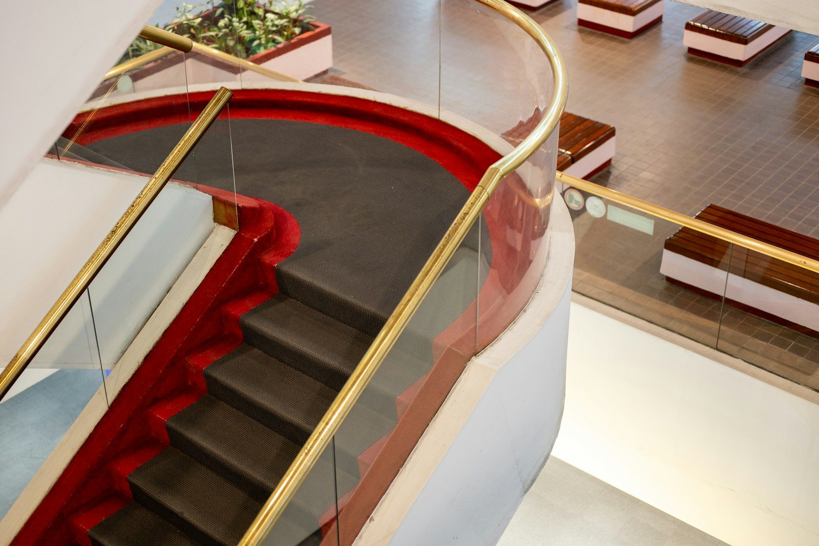 Modern staircase with glass railings and red accents